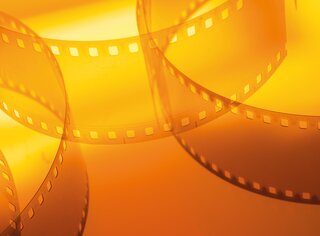 Filmstreifen vor orangem Hintergrund | © shutterstock/Serhii Yushkov