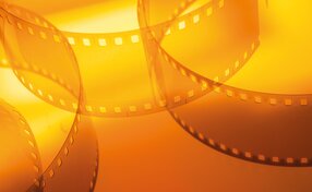 Filmstreifen vor orangem Hintergrund | © shutterstock/Serhii Yushkov